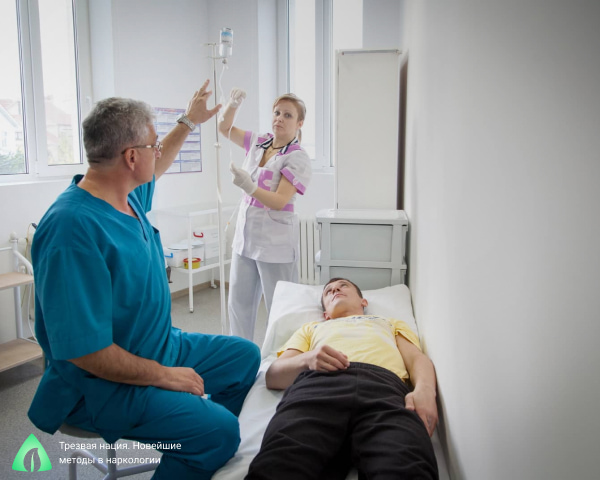 Врач с сестрой ставят капельницу пациенту
